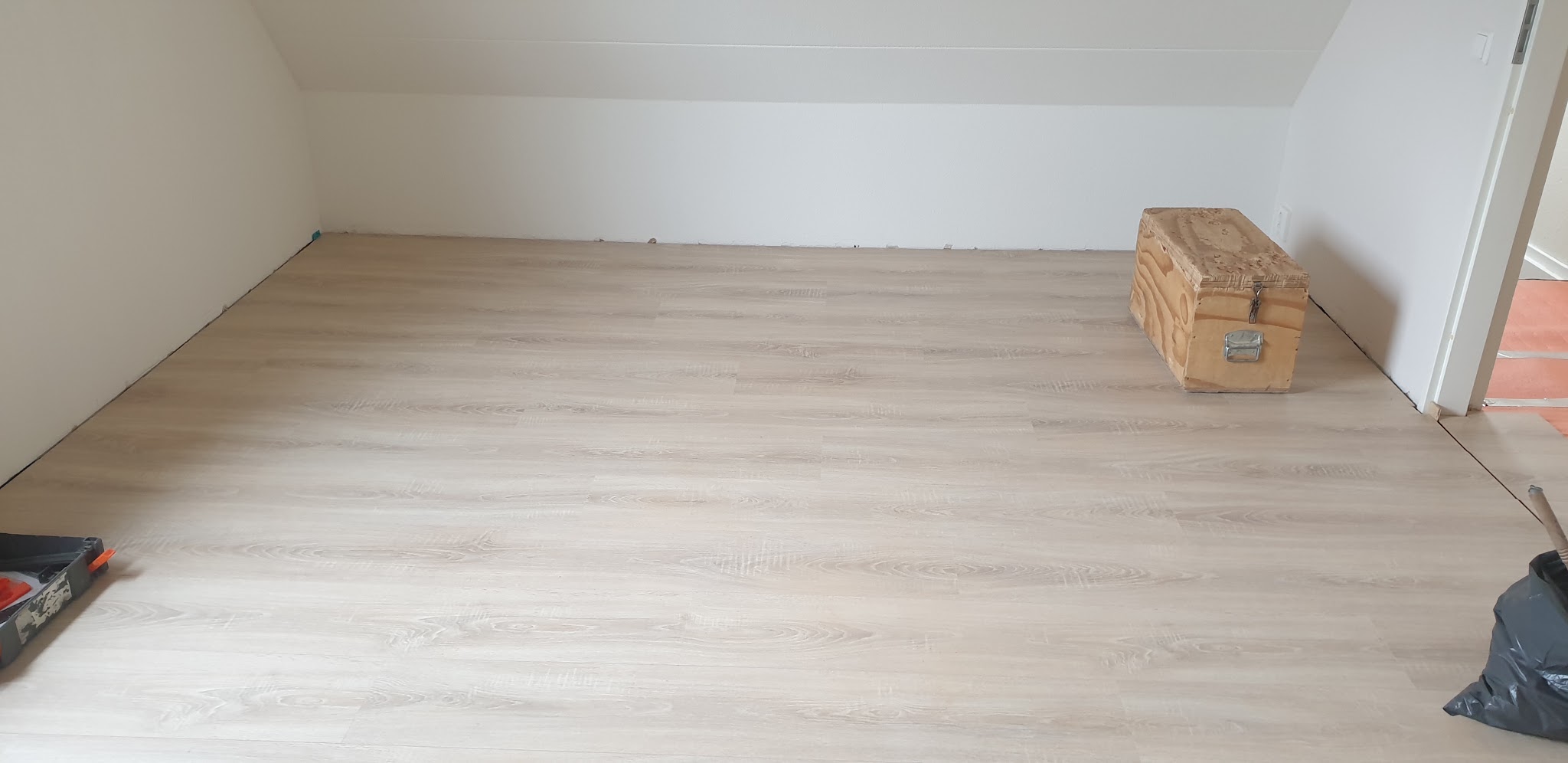 Lichte laminaatvloer gelegd in een lege kamer