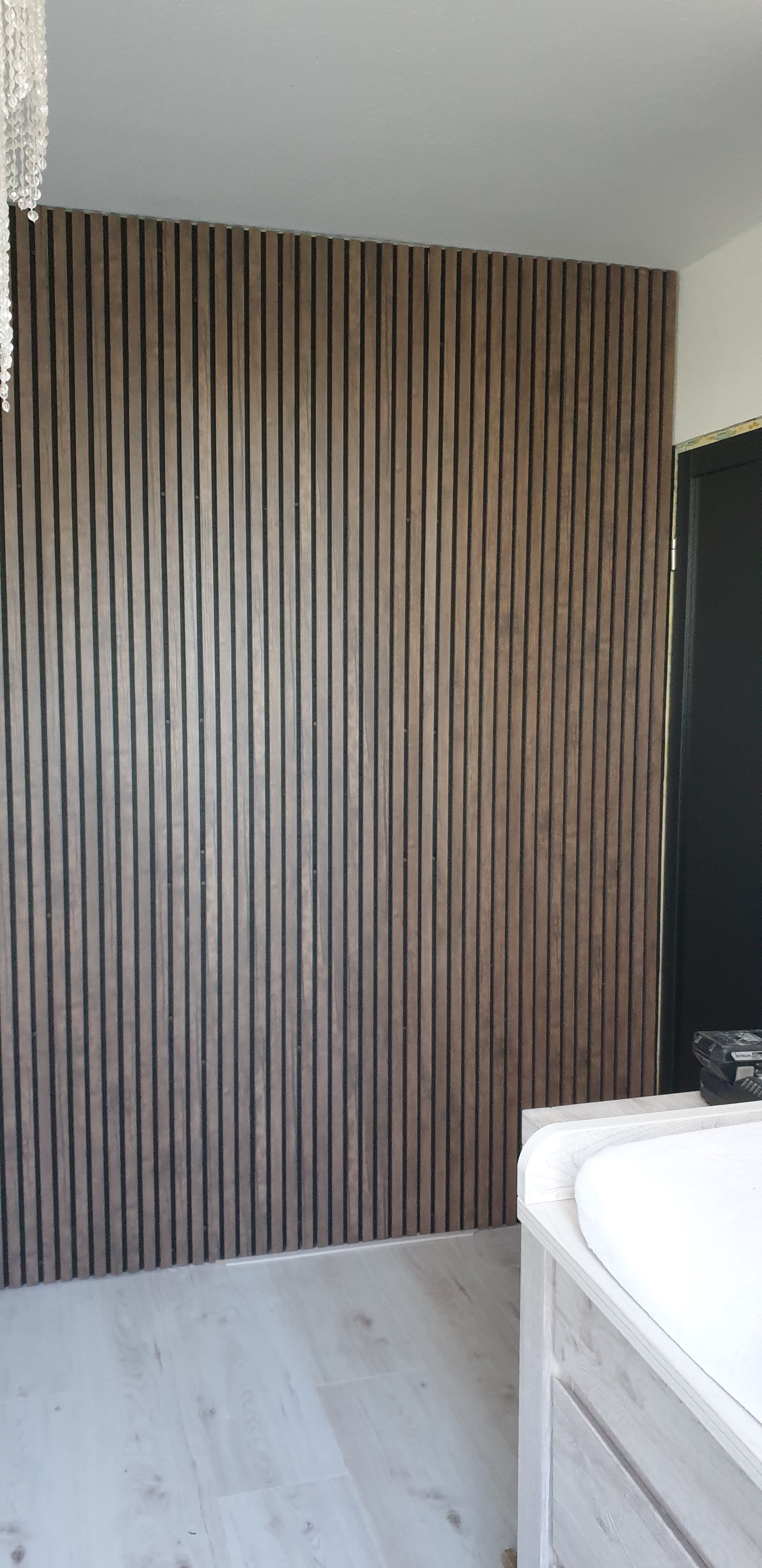 Houten lamellen wandpanelen op een slaapkamerwand